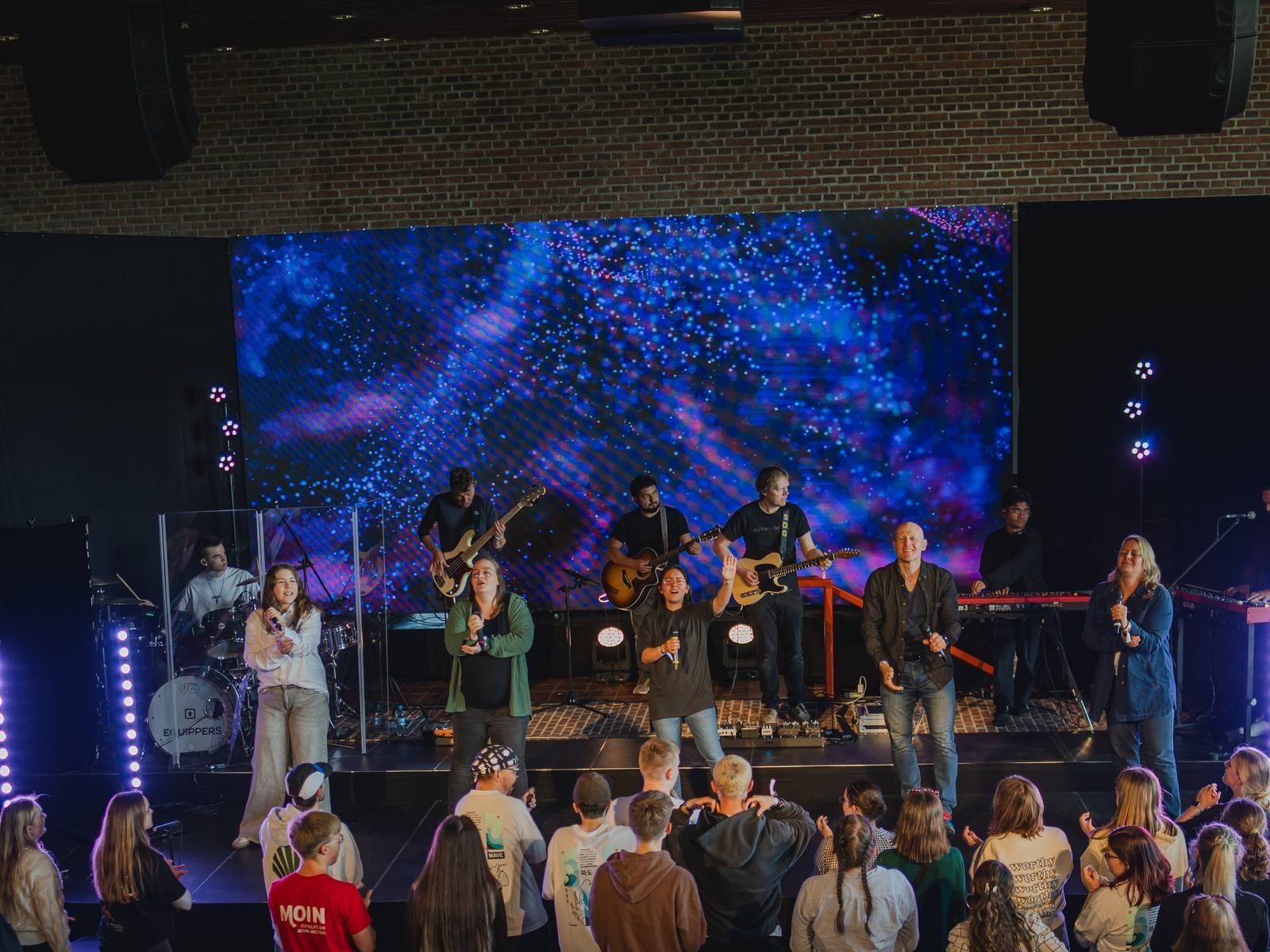 LED-Wall als Bühnenhintergrund bei einem Indoor-Event mit Band und Publikum